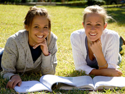 Studentinnen lesen auf Wiese